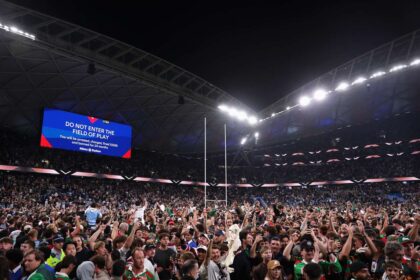 Szurkolok ozenlik el az Allianz Stadion gyephalfot hogy megunnepeljek Alex Johnston try golszerzesi rekordjat